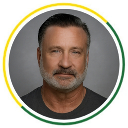 Confident middle-aged man with a full beard in a simple t-shirt, framed in vibrant colors.